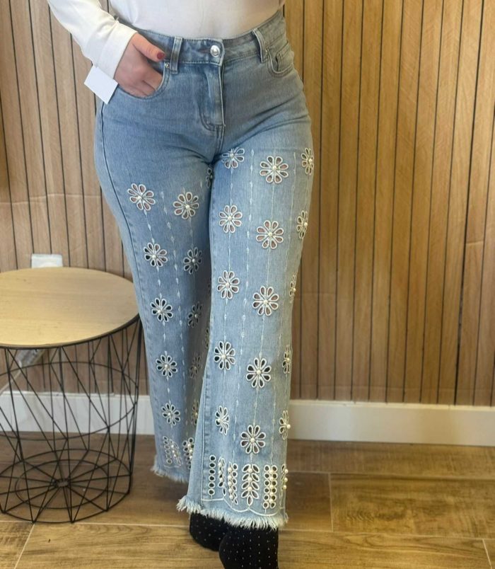 Jeans de mujer azul claro con bordado floral y cintura alta de corte recto.