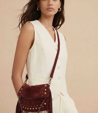 Bolso bandolera burdeos para mujer con flecos y tachuelas metálicas, estilo boho chic con asa larga ajustable.